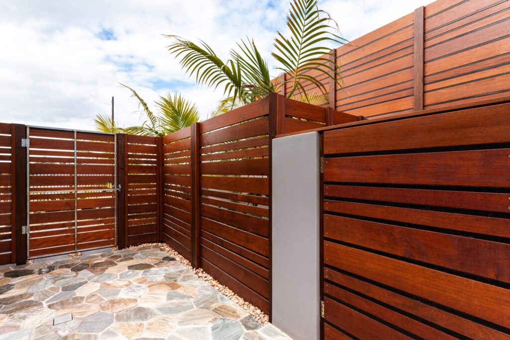 Backyard with wooden wall of modern house by ProNail Roofing Outdoor Living