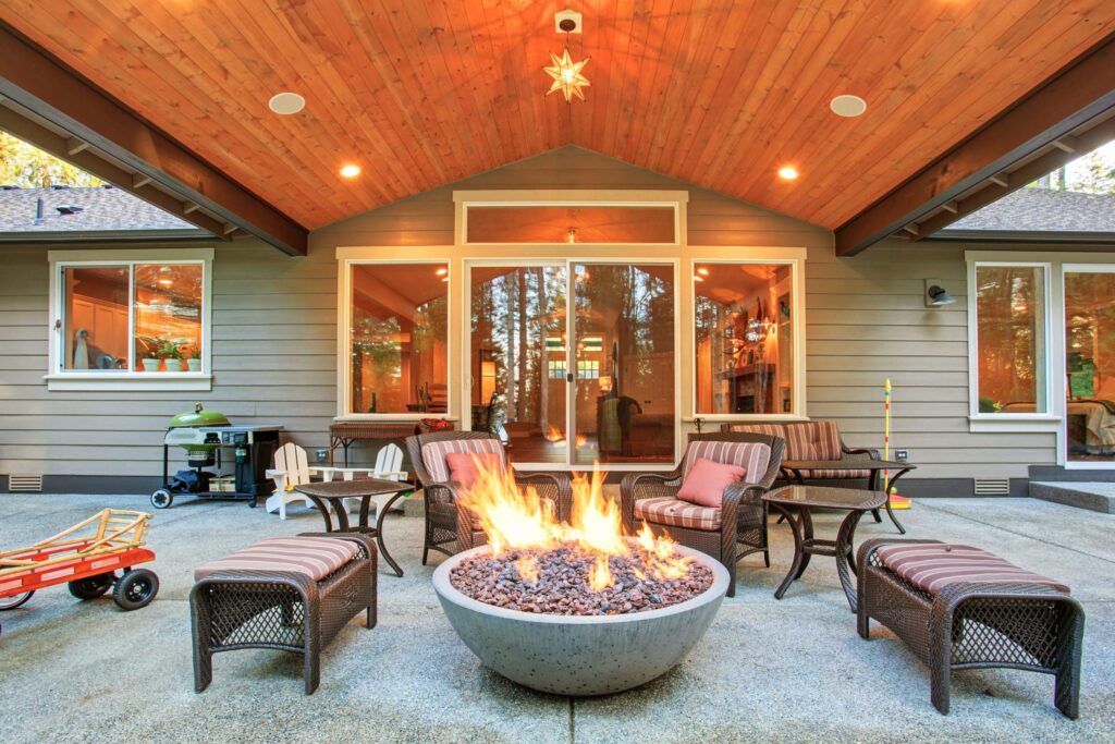 Large back yard with grass and covered patio with firepit. - Outdoor Living