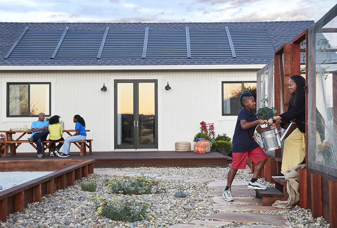 Solar panels on roof with family in backyard.