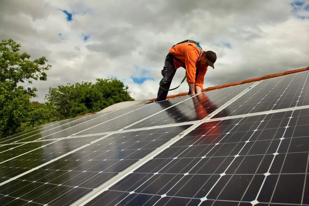 ProNail Roofing employee installing solar panels on the roof.